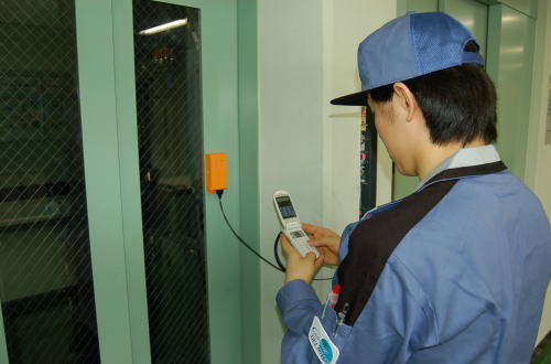 携帯電話を活用した昇降機保守支援システムによるメンテナンス風景